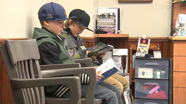 Deux jeunes garçons lisent un livre. Deux jeunes garçons lisent un livre.