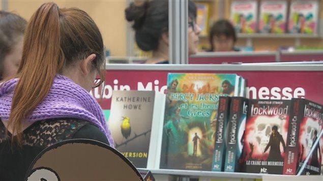 Une jeune femme devant un présentoir de livres Une jeune femme devant un présentoir de livres