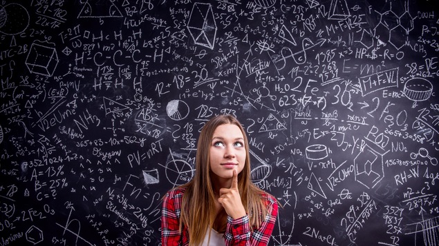 Une adolescente réfléchit devant un tableau noir où il y a des calculs mathématiques