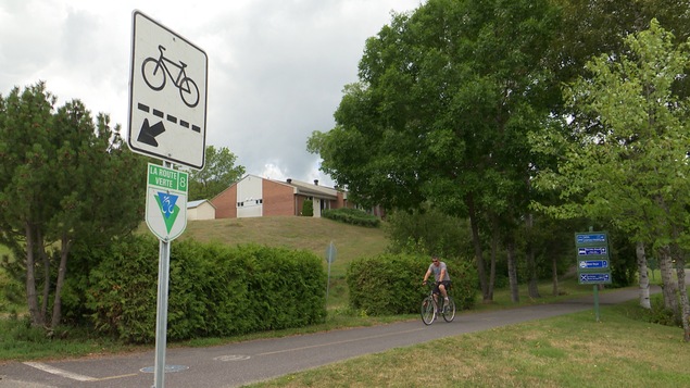 Un cycliste sur la Route verte près près de la marina de Cabano. Un cycliste sur la Route verte près près de la marina de Cabano.