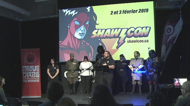 Gens sur une scène devant un écran qui dit que Shawinigan aura lieu les 2 et 3 février 2019
