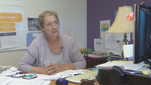 Une femme entourée de piles de papier dans son bureau Une femme entourée de piles de papier dans son bureau