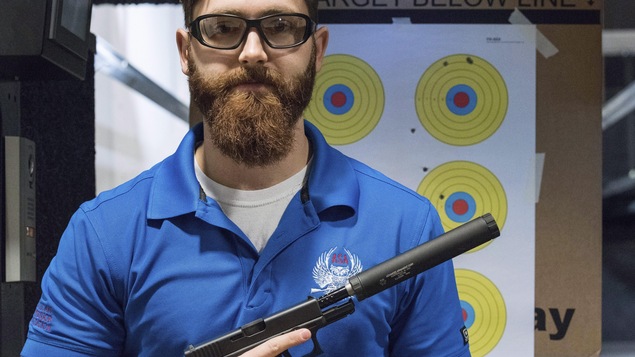 Un membre du Groupe américain pour les silencieux pose avec son arme. Un membre du Groupe américain pour les silencieux pose avec son arme.