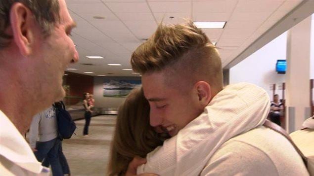 Simon Carrière entouré des siens à l'aéroport international Stanfield d'Halifax lors de son retour du Népal après le séisme meurtrier de 2015 Simon Carrière entouré des siens à l'aéroport international Stanfield d'Halifax lors de son retour du Népal après le séisme meurtrier de 2015
