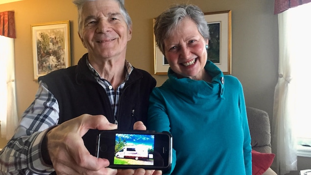 Robert Michon et Monique Boucher montrent une photo sur leur téléphone de leur véhicule récréatif.