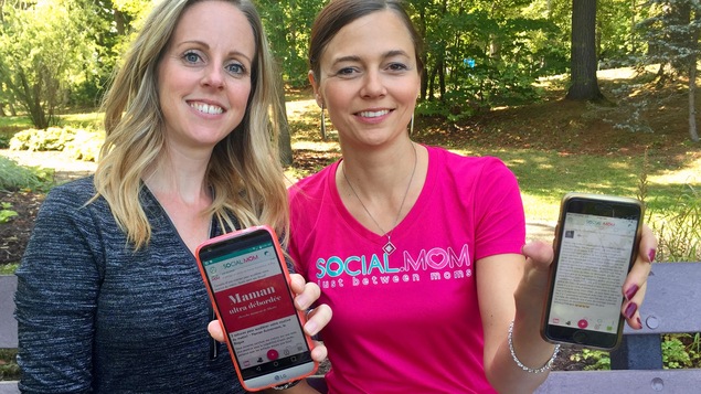 Marie-Pierre Cloutier et la créatrice de l'application social.mom, Audrey Poulin tiennent chacune un cellulaire dans leur main. Sur l'écran, l'application social.mom. Elles sont assises sur un banc de parc.