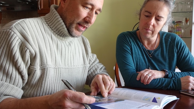Sophie Arsenault et André Pineault consultent des livres sur les grandes traversées en voilier. Sophie Arsenault et André Pineault consultent des livres sur les grandes traversées en voilier.