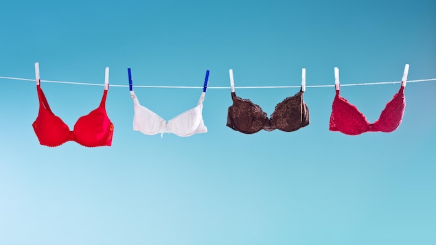 Des soutiens-gorges accrochés sur une corde à linge.