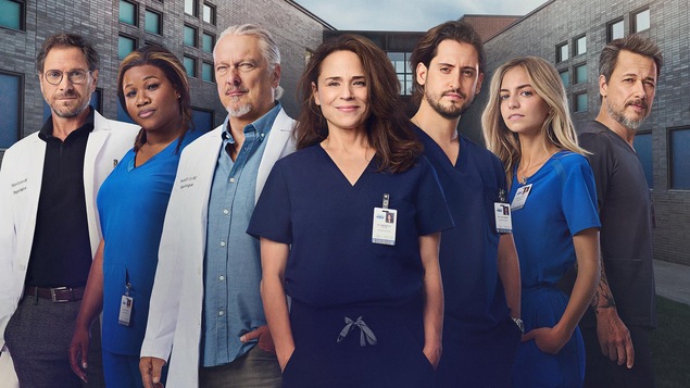 Les sept personnages principaux de la série posent l'un à côté de l'autre, à l'extérieur d'un hôpital. 
