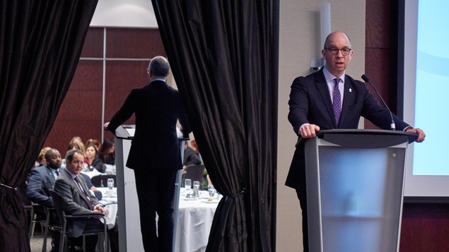 Le président de la Fédération des chambres de commerce du Québec, Stéphane Forget, faisant un discours devant des personnes assises autour de tables. Le président de la Fédération des chambres de commerce du Québec, Stéphane Forget, faisant un discours devant des personnes assises autour de tables.