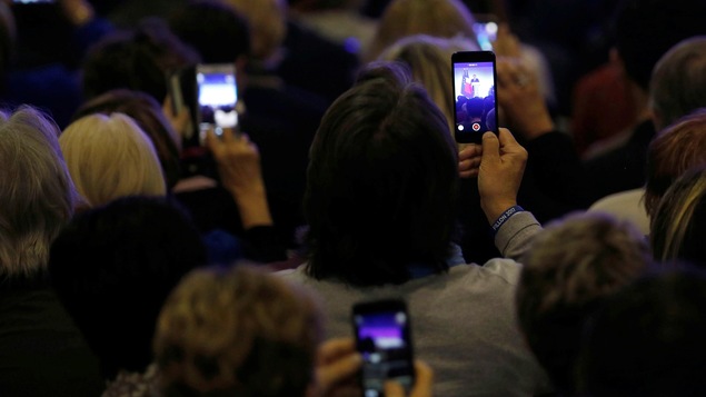 Des participants à un rassemblement du candidat François Fillon en France prennent des images avec leur téléphone. Des participants à un rassemblement du candidat François Fillon en France prennent des images avec leur téléphone.