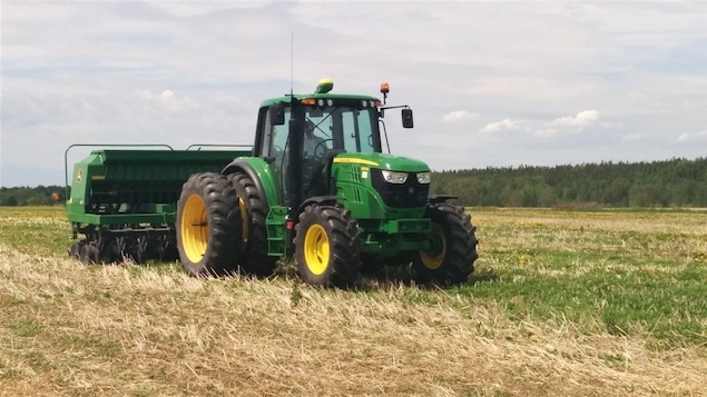 Un camion laboure une terre agricole