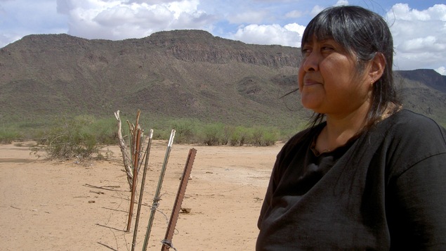 En 2006, une membre de la tribu Tohono O'Odham se tient devant une clôture qui sépare le Mexique et les États-Unis. En 2006, une membre de la tribu Tohono O'Odham se tient devant une clôture qui sépare le Mexique et les États-Unis.