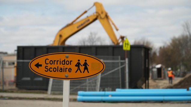 Un panneau indiquant corridor scolaire près d'un chantier. 