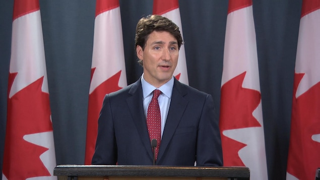 Le premier ministre devant un podium lors d'une conférence de presse.