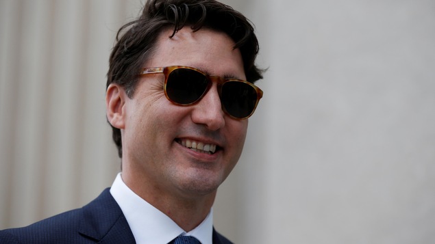 Le premier ministre Trudeau, lunettes soleil au visage, marche dans les rues d'Ottawa. Le premier ministre Trudeau, lunettes soleil au visage, marche dans les rues d'Ottawa.
