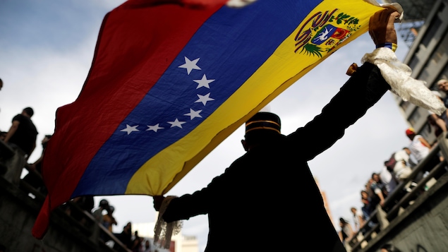 Un homme tient derrière lui un drapeau du Venezuela lors d'une manifestation le 24 juillet 2017.