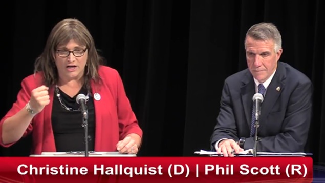 La candidate Christine Hallquist parle au micro, alors que Phil Scott l'écoute
