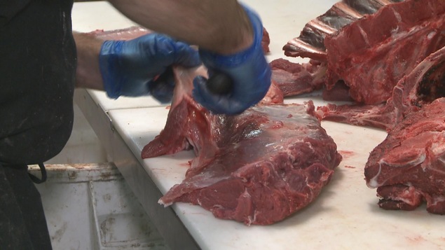 De la viande de gibier est coupée.