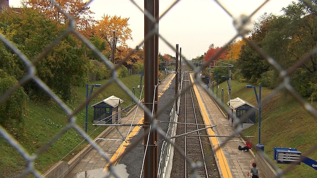 Le rail vu à travers le grillage d'une clôture.