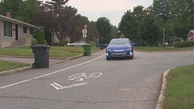 Voiture roulant dans une voie ayant une signalisation de vélo Voiture roulant dans une voie ayant une signalisation de vélo