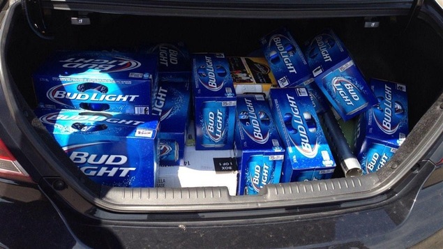 Le coffre d'une voiture rempli de caisses de bière