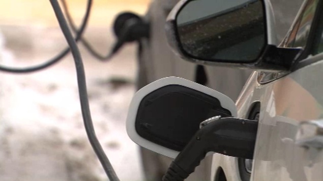 Une câble est branché là où se trouverait la pompe sur une voiture à essence.
