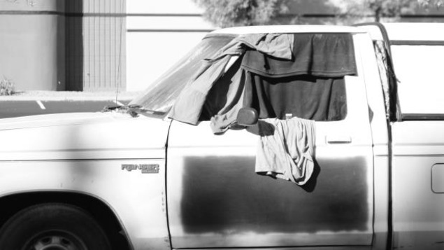 Une voiture avec des vêtements accrochés aux fenêtres pour en cacher l'intérieur. Une voiture avec des vêtements accrochés aux fenêtres pour en cacher l'intérieur.