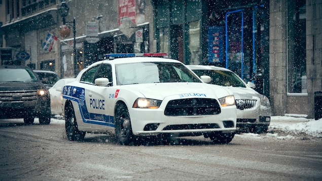 Une auto-patrouille du Service de police de la Ville de Montréal roule sous la neige.