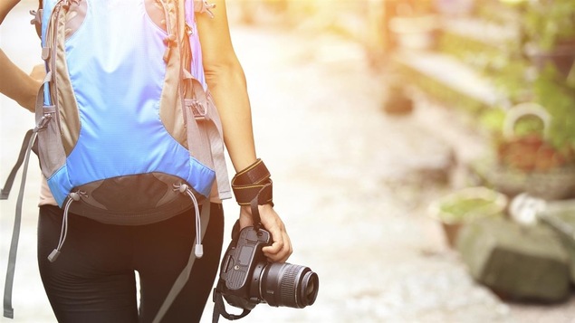 Une femme portant un sac à dos et un appareil photo
