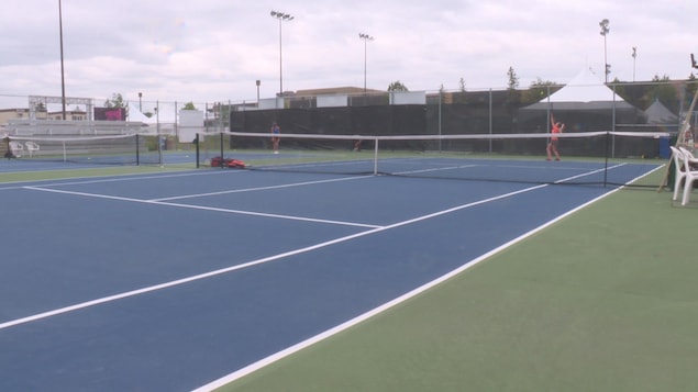 un court de tennis à Gatineau où on peut voir un joueuse s'élancer pour un service un court de tennis à Gatineau où on peut voir un joueuse s'élancer pour un service