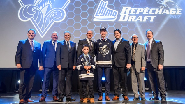 Alexis Lafrenière portant le chandail de l'Océanic de Rimouski et entouré de l'équipe de direction de la formation Alexis Lafrenière portant le chandail de l'Océanic de Rimouski et entouré de l'équipe de direction de la formation