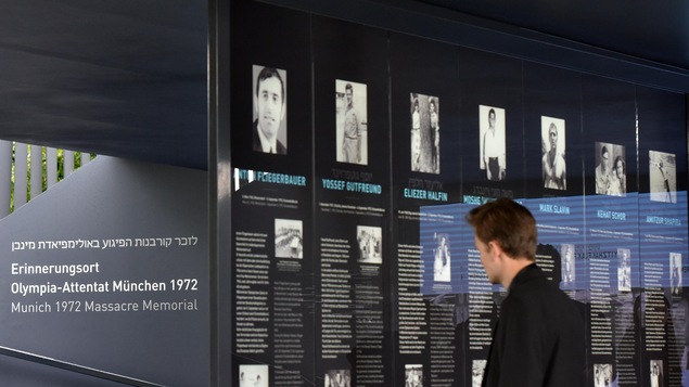 Un passant lit une des biographies du mémorial de Munich dédié aux 11 athlètes israéliens tués le 5 septembre 1972. Un passant lit une des biographies du mémorial de Munich dédié aux 11 athlètes israéliens tués le 5 septembre 1972.