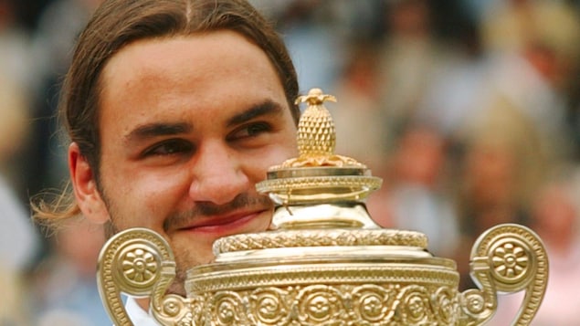 Roger Federer, souriant, avec le premier trophée qu'il a gagné à Wimbledon, en 2003 Roger Federer, souriant, avec le premier trophée qu'il a gagné à Wimbledon, en 2003