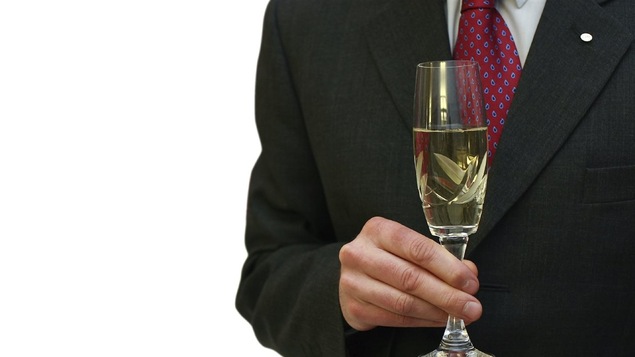 Un homme d'affaires boit de l'alcool.