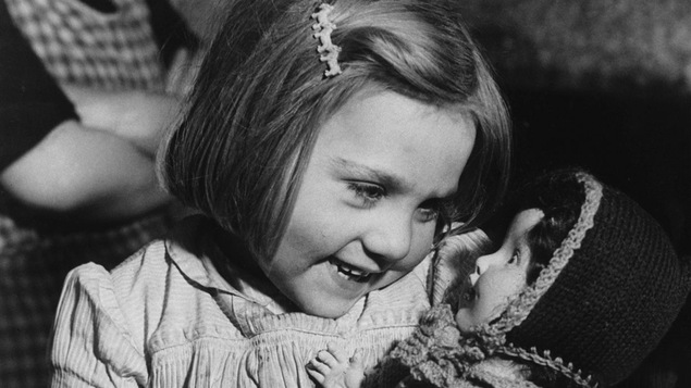 Une petite fille reçoit une poupée en 1946.