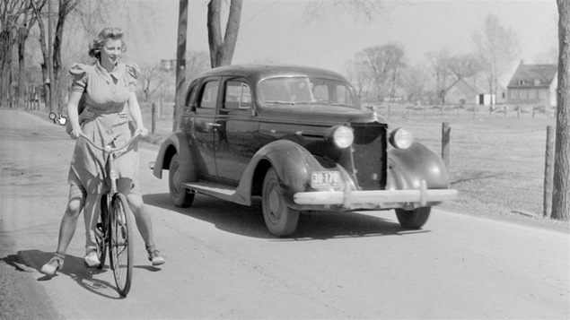 Une cycliste effectue une randonnée avec une deuxième personne sur son vélo en 1941.