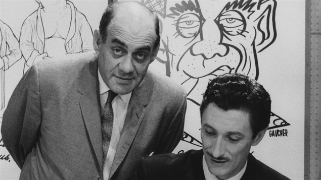 L'animateur Miville Couture et le chanteur Yoland Guérard posent devant des caricatures en 1959.
