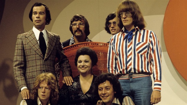 Toute l'équipe d'<i>Appelez-moi Lise</i> : le coanimateur Jacques Fauteux, un musicien non identifié, le batteur Guy Parent, l'animatrice Lise Payette, le bassiste Jean-Guy Chapados, le guitariste Richard Ring et le directeur musical François Cousineau