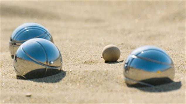 Des boules de pétanque dans le sable.