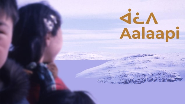 Photo de deux Inuits sur fond de paysage enneigé avec l'inscription Aalaapi en inuktitut.