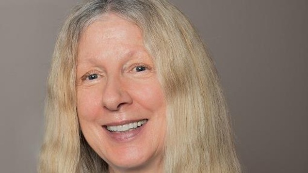 Adèle Arpin formatrice en langue à l'Alliance française du Manitoba. Elle a les bras croisés avec un sourire au visage.
