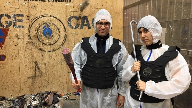 Les deux protagonistes sont vêtus d'un habit protecteur blanc avec un plastron sur le torse et un bâton de baseball ainsi qu'une barre de corbeau dans les mains.