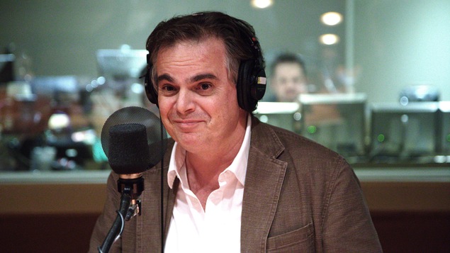 Alexandre Jardin, des écouteurs sur la tête, assis devant un micro