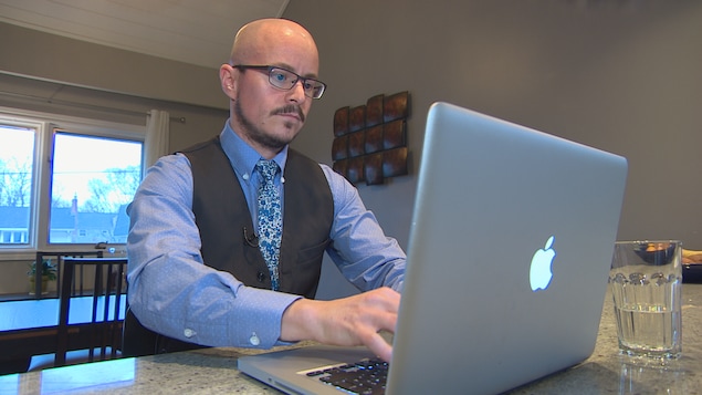 Le professeur Alexandre Baril tape sur son ordinateur.