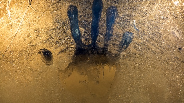 La trace d'une main sur une vitre givrée.
