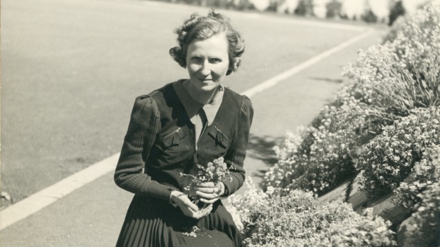 Marcelle Gauvreau cueille un bouquet de fleurs.