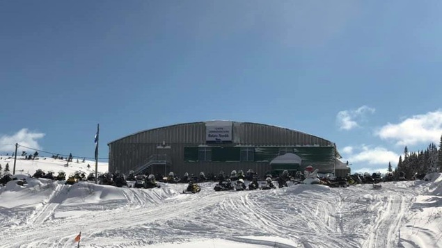 Centre communautaire Relais Nordik (aréna) à La Tabatière, sur la Basse-Côte-Nord, en hiver, avec de nombreuses motoneiges stationnées devant