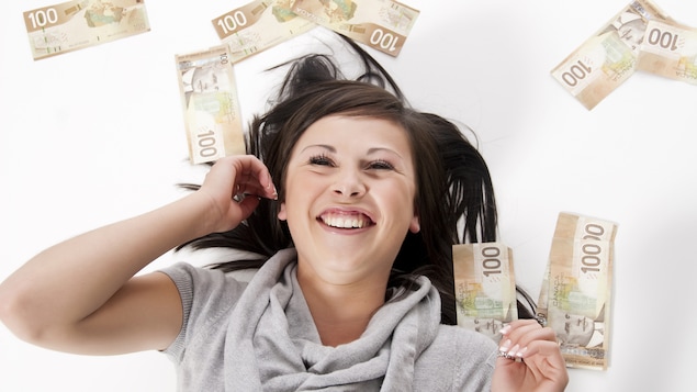 Une jeune femme est couchée et est entourée de billets de 100 $.