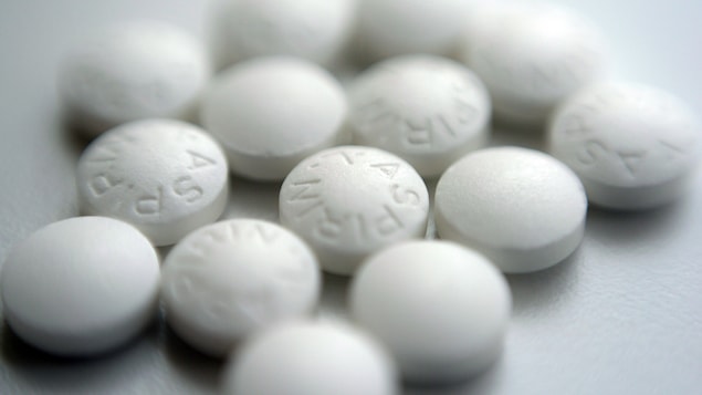 Des comprimés d'aspirine en gros plan sur une surface blanche.